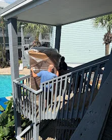 BRS crew moving items down porch stairs